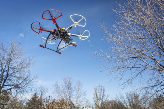 FORT COLLINS, CO, USA, December 20,  2014:  DJI  F550 Flame Wheel  hexacopter drone, assembled from a kit, flying in a backyard among trees.