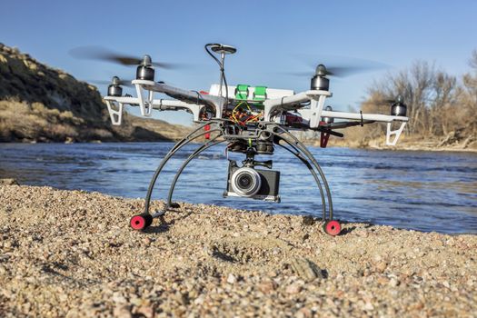 WILDCAT, CO, USA, March 9,  2015:  DJI F550 Flame Wheel  hexacopter drone landing with a camera on river shore.