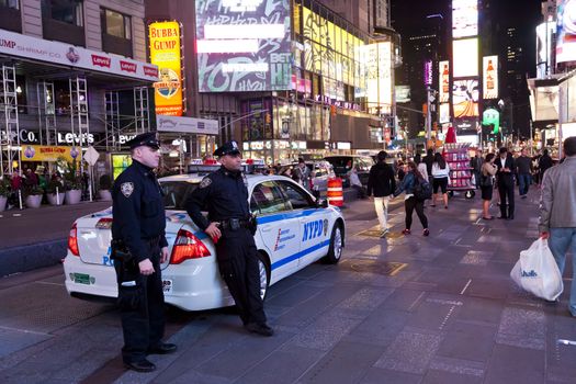 New York City, USA - OCT 9, 2014 : Police car and policemen in the Times Square. Times Square is major commercial intersection in New York and one of the most visited and protected tourist attractions in the world.