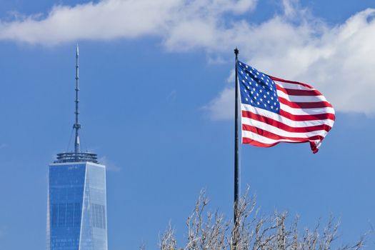 New York, USA - October 8, 2014: Freedom Tower in Lower Manhattan and US Flag. One World Trade Center is the tallest building in the Western Hemisphere and the third-tallest building in the world.