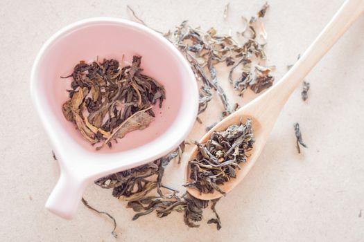 Oolong tea in wooden spoon and ceramic cup, stock photo