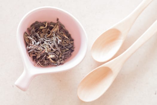 Oolong tea in ceramic cup and empty wooden spoons, stock photo