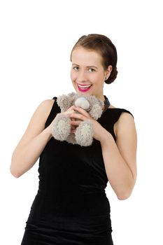 attractive smiling brunette holding teddy bear in a black dress isolated on white