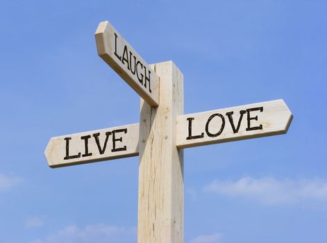 Signpost with the words "Live Laugh Love" over a blue sky background
