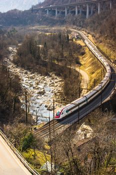 typical Swiss landscape, valleys between mountains, snow and trains