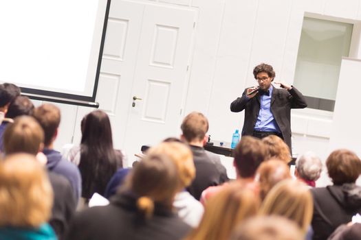 Speaker Giving a Talk at Business Meeting. Audience in the conference hall. Business and Entrepreneurship. Copy space on white board.