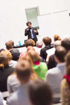 Speaker Giving a Talk at Business Meeting. Audience in the conference hall. Business and Entrepreneurship. Copy space on white board.