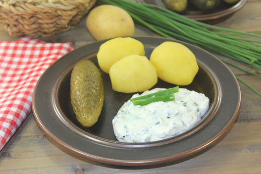 Herb curd with boiled potatoes and pickled cucumber