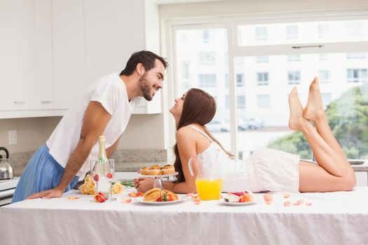 Young couple having a romantic breakfast at home in the kitchen