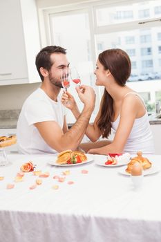 Cut couple drinking champagne together at home in the kitchen