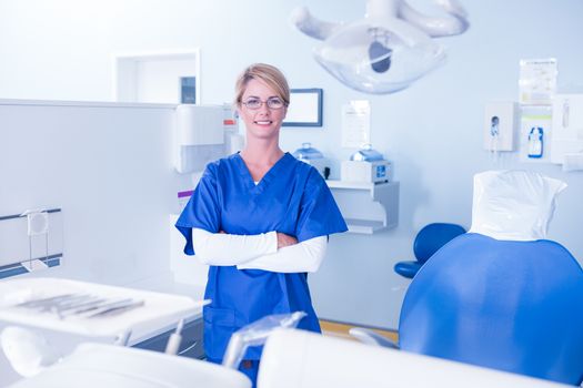 Dentist smiling at camera with arms crossed at the dental clinic