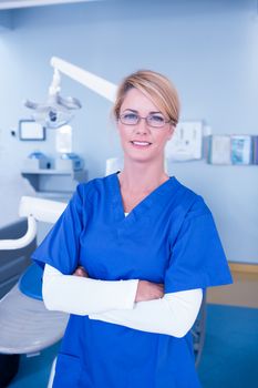 Dentist smiling at camera with arms crossed at the dental clinic