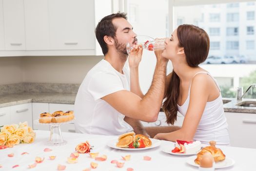 Cut couple drinking champagne together at home in the kitchen