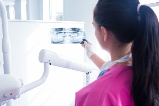 Focused assistant studying x-rays at the dental clinic