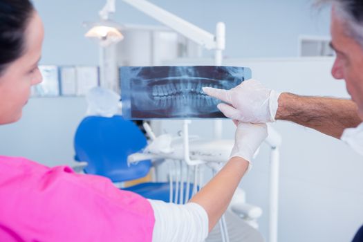 Dentist and assistant examining x-ray together at the dental clinic