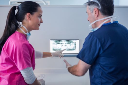 Dentist and assistant looking at x-ray together at the dental clinic