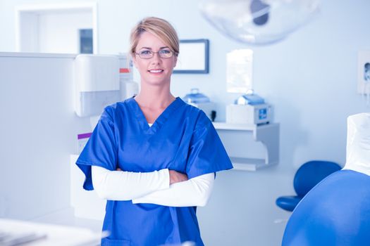 Portrait of a dentist smiling at camera with arms crossed at the dental clinic