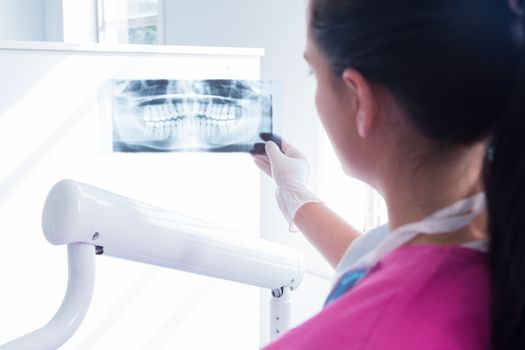 Focused assistant studying x-rays at the dental clinic