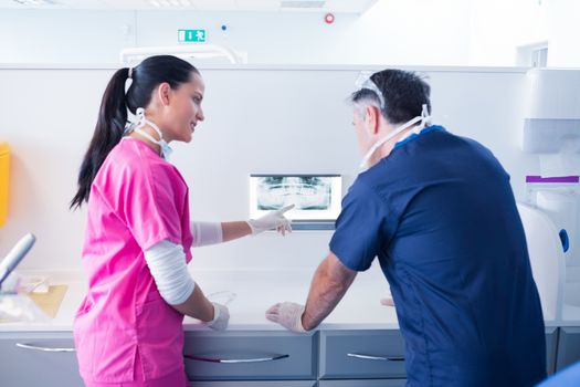 Dentist and assistant looking at x-ray together at the dental clinic