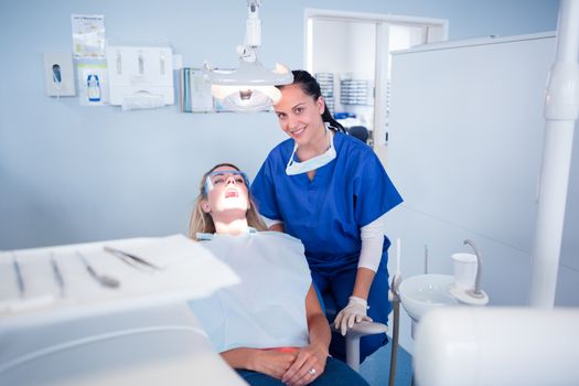 Dentist sitting over patient in the chair at the dental clinic