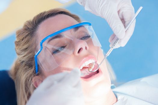 Close up of a patient with mouth open under the light at the dental clinic