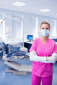 Dentist in pink scrubs standing with arms folded at the dental clinic