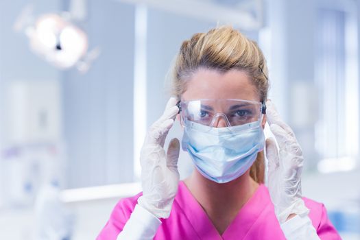 Dentist in surgical mask and protective glasses at the dental clinic