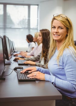 Happy woman in computer room smiling at camera in the office