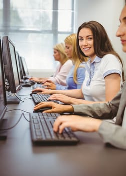 Happy woman in computer room smiling at camera in the office