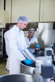 Chemist team working together while girl writing in the factory