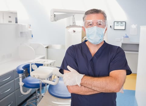 Portrait of a dentist with arms crossed and surgical mask in dental clinic