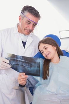 Pediatric dentist explaining to young patient the x-ray in dental clinic