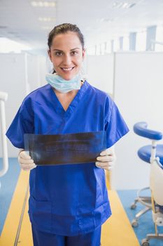 Happy dentist examining a x-ray in dental clinic