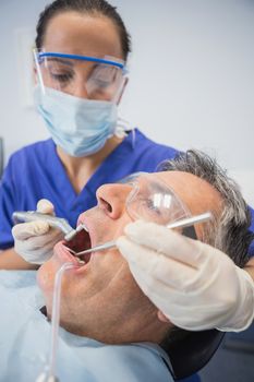 Dentist examining a patient with tools in dental clinic