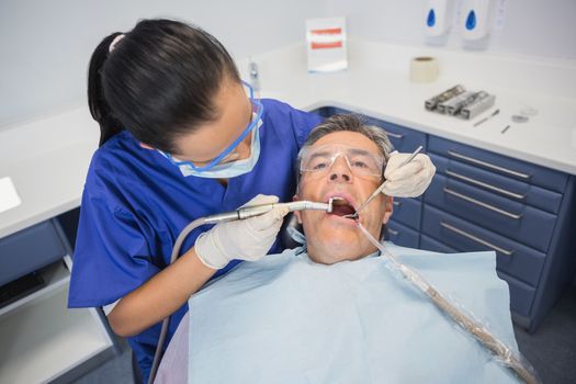 Dentist examining a patient with tools in dental clinic