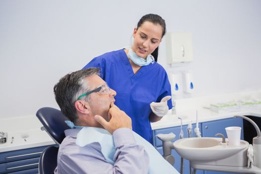 Dentist talking with her patient in dental clinic