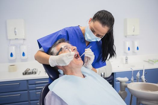 Dentist examining a patient with tools in dental clinic