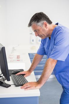 Dentist concentrated about computer monitor in dental clinic