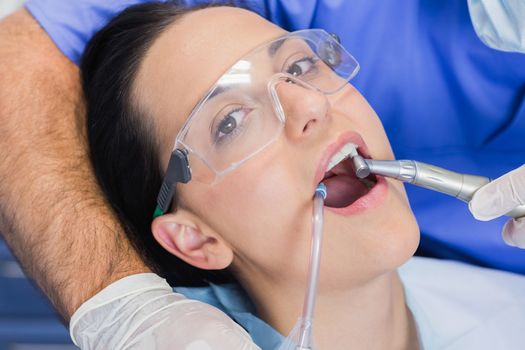 Portrait of a patient her mouth open with tools in dental clinic