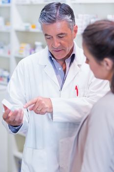 Pharmacist speaking with cheerful young customer in the pharmacy