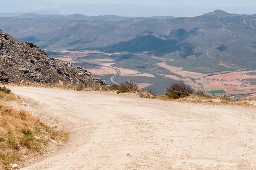 SWARTBERG PASS, SOUTH AFRICA - JANUARY 2, 2015: View from the top of the historic Swartberg (Black Mountain) Pass. The road between Oudtshoorn and Calitzdorp is visible down to the East.