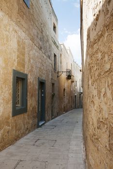 old street with ligths and amber building on the island malta with blue sky and white clouds obavo the street