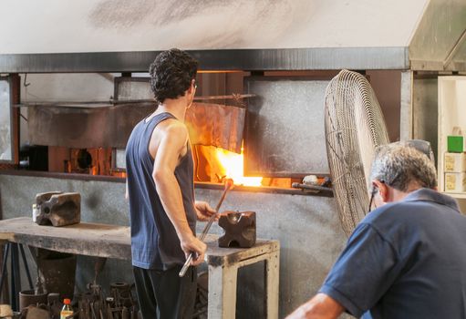 MDINA,MALTA-SEPTEMBERT 29, 2011: Glass blower making glass in hot fire ,on September 29 2011, the glass blowers are showng their profession to tourist and sell the product when finished