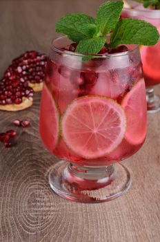 Pomegranate cocktail with slices of lime, mint and ice