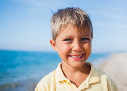 Summer vacation - Portrait of lovely boy walking on the beach near water