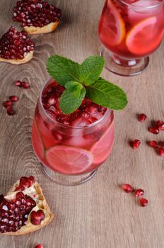 Pomegranate cocktail with slices of lime, mint and ice