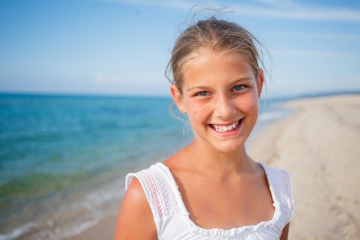 Summer vacation - Portrait of lovely girl walking on the beach near water