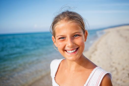 Summer vacation - Portrait of lovely girl walking on the beach near water