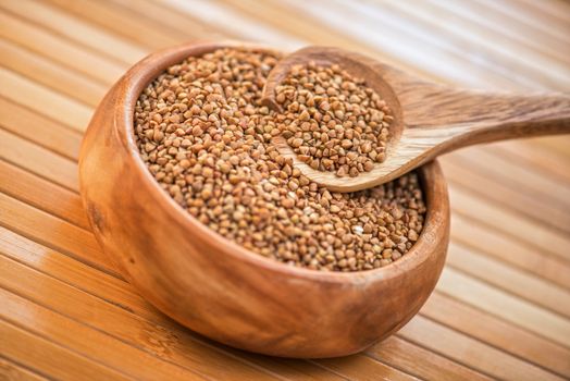 buckwheat at wooden plate on wooden background
