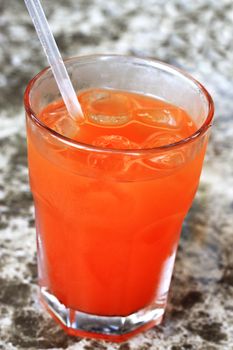 Glass of drink with a straw on the marble table